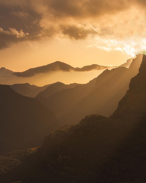 Capture verticale de montagnes rocheuses pittoresques au coucher du soleil couvert de nuages, au Bhoutan