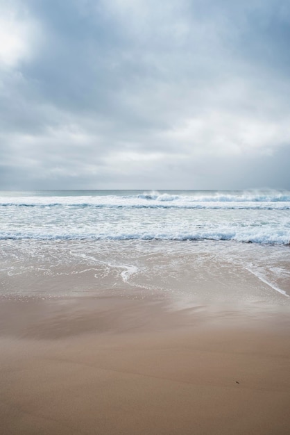 Capture verticale d'une plage de sable lors d'une soirée nuageuse