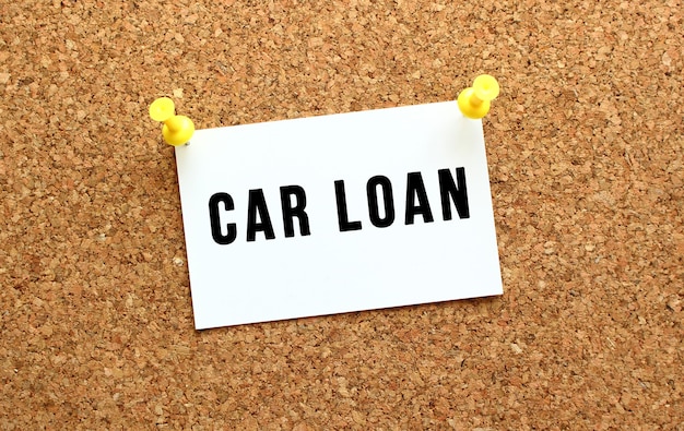 CAR LOAN est écrit sur une carte attachée au tableau de liège avec un bouton. Rappel sur le tableau de bord. Concept d'entreprise.