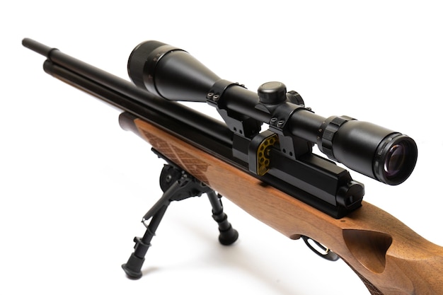 La carabine à air comprimé en bois marron pour champ de tir avec viseur optique isolé sur fond blanc