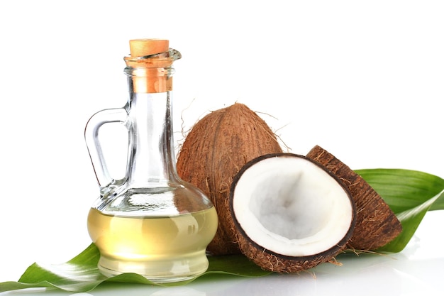 Carafe à l'huile de noix de coco et noix de coco isolées sur blanc