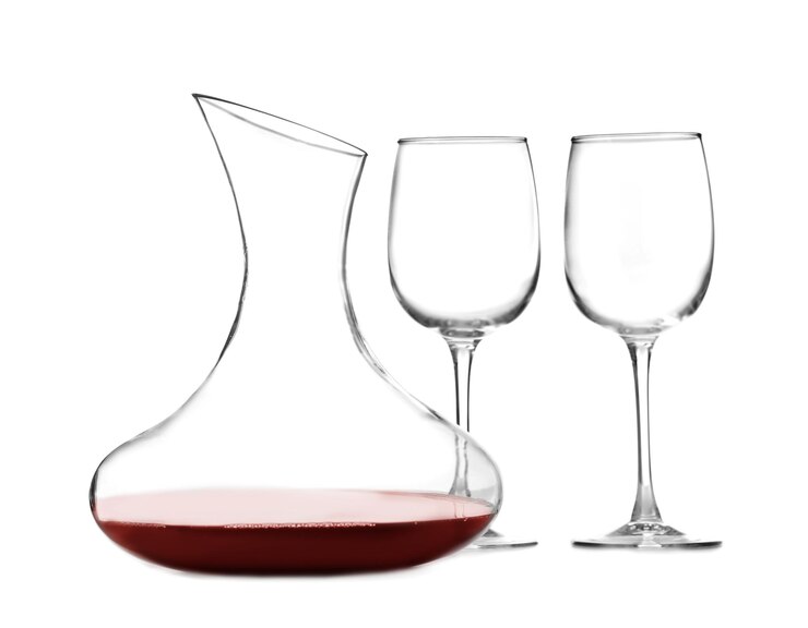 Photo carafe en verre de vin rouge et verres sur fond blanc