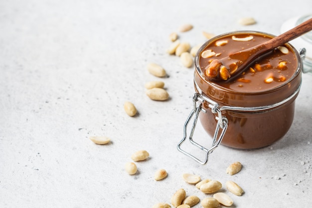 Caramel salé fait maison avec noix dans un bocal en verre, espace de copie. Ingrédient pour les gâteaux de gâteau.