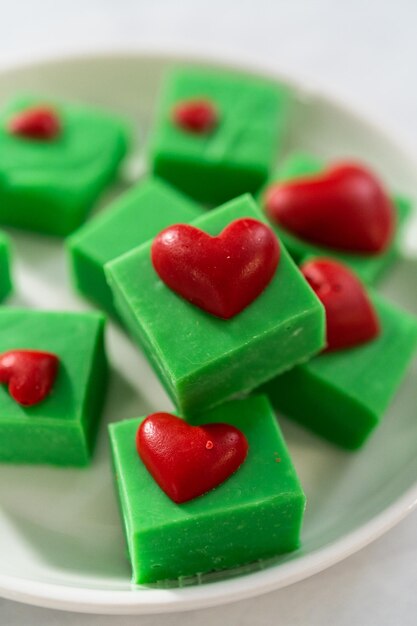 Photo un caramel vert avec des cœurs rouges.