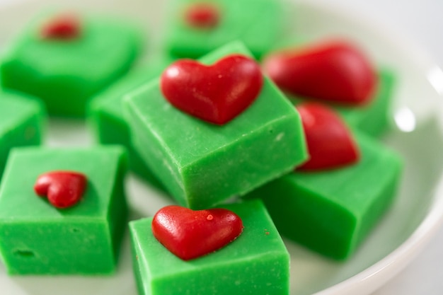 Photo un caramel vert avec des cœurs rouges.