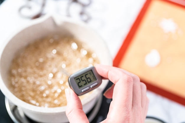 Caraméliser le sucre en casserole pour faire des sucettes maison.