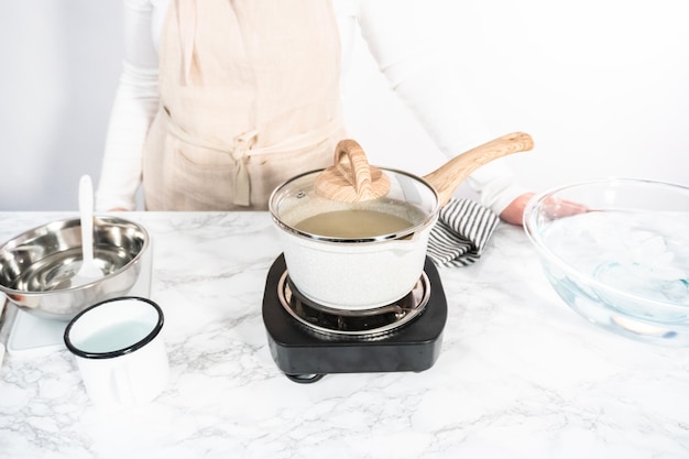 Caraméliser le sucre en casserole pour faire des sucettes maison.