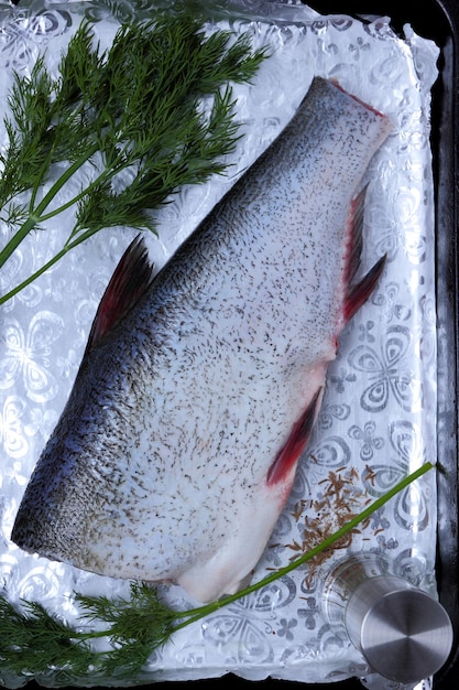 Des carcasses de poisson décortiquées reposent sur une déco. Carpe sur feuille d'argent aux épices. Prêt à cuire dans un grill