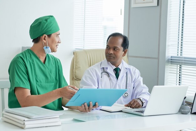 Cardiologue montrant le cardiogramme des patients au médecin généraliste et discutant des symptômes de la maladie