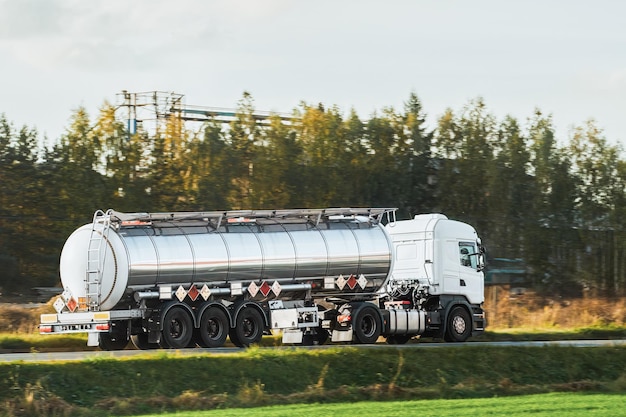 Cargo de carburant et d'huile liquide Semi-camion sur l'autoroute Transporteur de gaz comprimé Truck dans la lumière du soir Transport de produits pétroliers