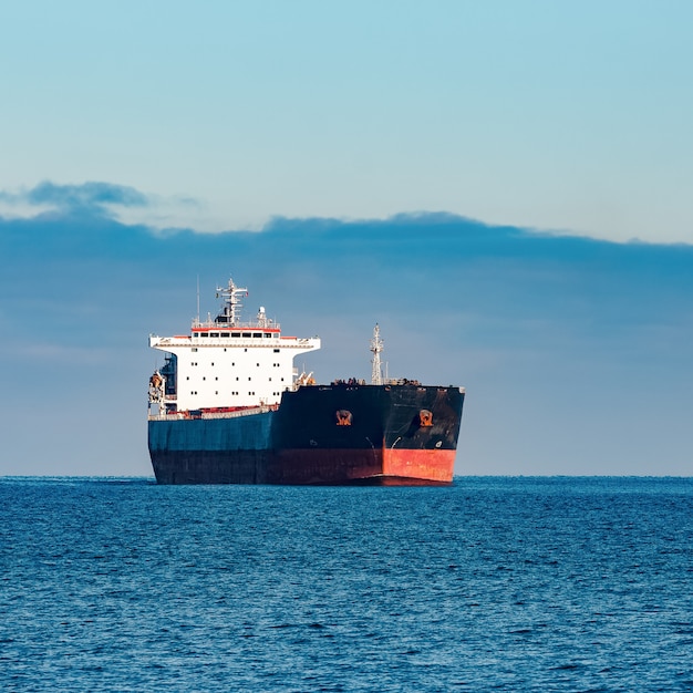 Cargo noir se déplaçant dans l'eau de la mer Baltique encore. Riga, Europe