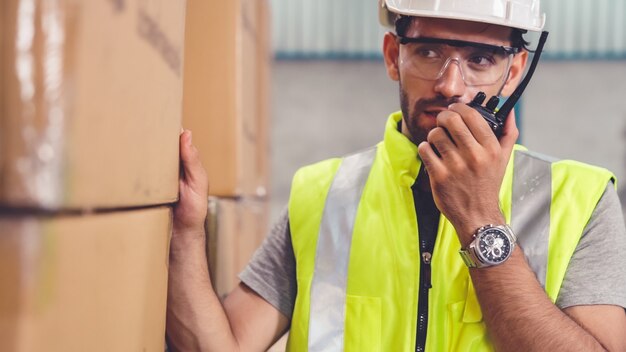 Un cargo professionnel parle sur une radio portable pour contacter un autre travailleur