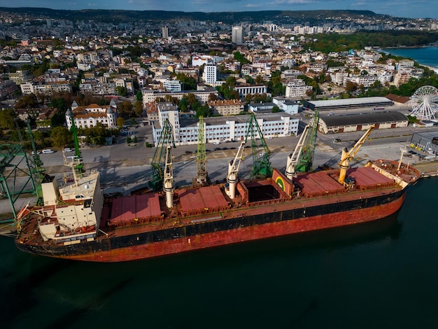 un cargo ou un vraquier chargé à ras bord de céréales se prépare au départ, les marins qui travaillent sur le pont terminent leur travail, vue aérienne de dessus