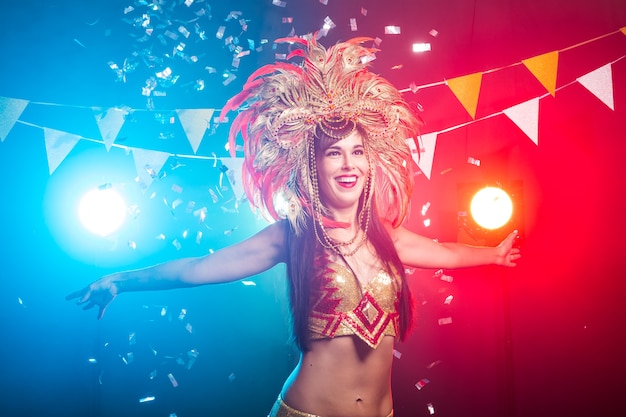 Carnaval, danseur et concept de vacances - Portrait d'une femme sexy dans un somptueux costume de plumes de carnaval coloré. Vie nocturne de la danseuse.