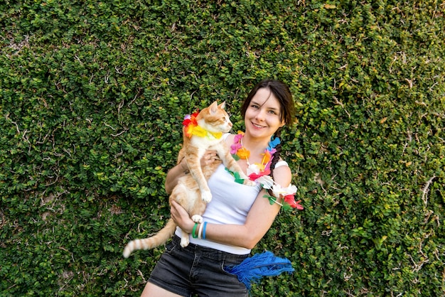 Carnaval pour animaux de compagnie femme tenant un chat jaune à la fête du carnaval