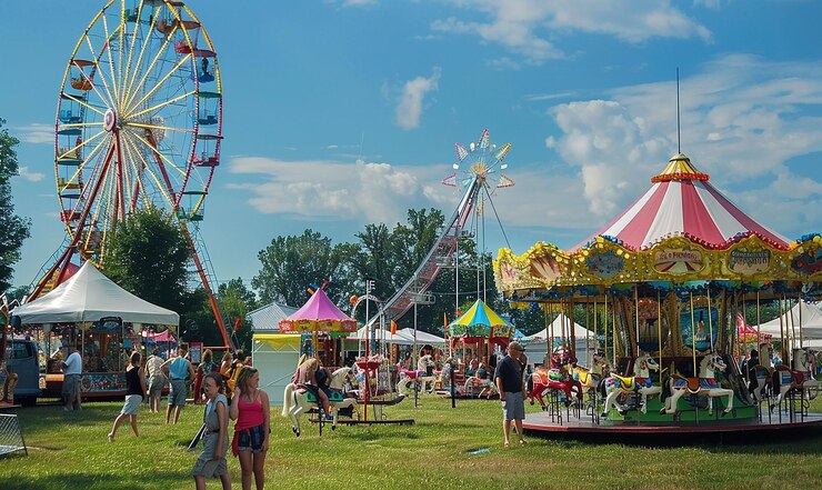 Photo un carnaval avec une roue en ferris et des gens en arrière-plan