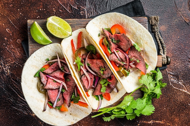 Carne Asada Tacos avec steak grillé sauce verte jalapenos et oignon Cuisine mexicaine Vue de dessus sur fond sombre