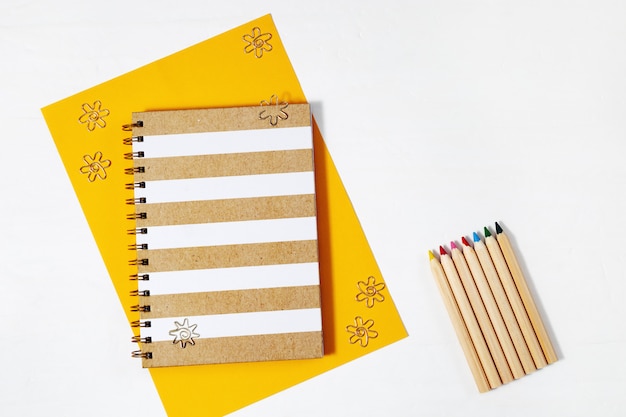 Carnet fermé et crayons de couleur pour le dessin. Espace de travail pour personne créative.