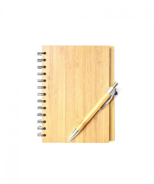 Carnet de notes en bois avec un stylo brun isolé sur blanc