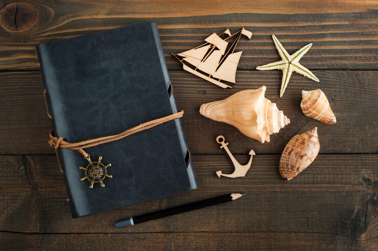 Carnet de notes, coquillages et bateau en bois
