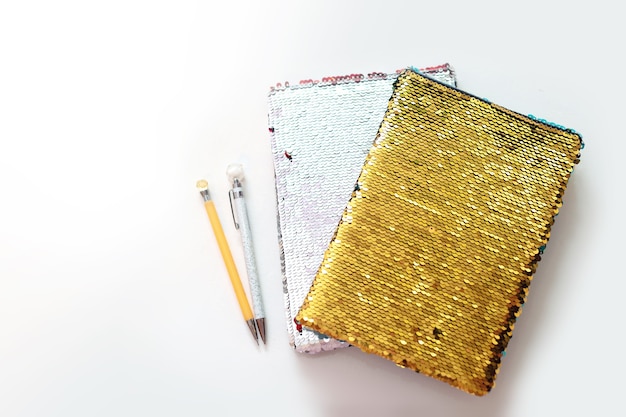 Carnet d'or avec des paillettes avec un stylo