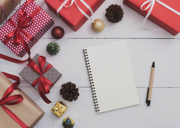 Carnet et stylo avec boîte de cadeau de vacances de Noël et nouvel an avec ornement décoratif sur la table en bois