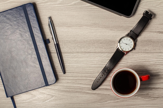 Carnet stylo montre homme tasse de café et tablette