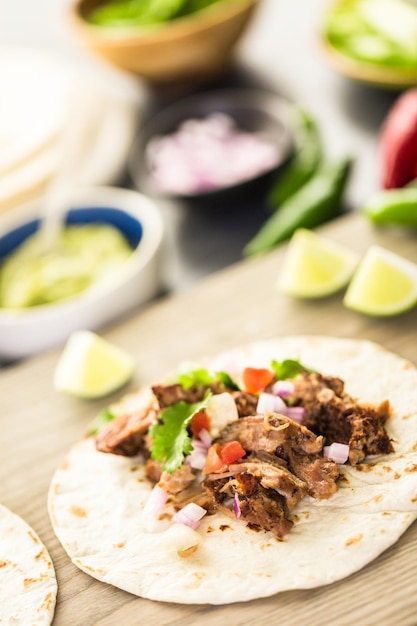 Carnitas de porc effiloché avec pico de gallo sur une tortilla de farine.