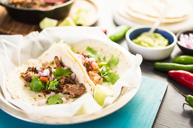 Carnitas de porc effiloché avec pico de gallo sur une tortilla de farine.