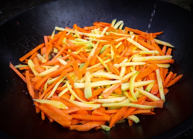 Carotte jaune et orange dans le processus de cuisson du pilaf au chaudron
