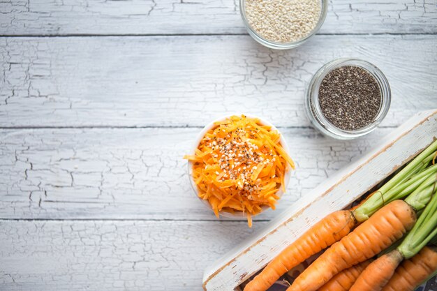 Carotte de légumes aux graines de chia, sésame, carottes fraîches. Manger propre, concept de nourriture végétarienne crue.