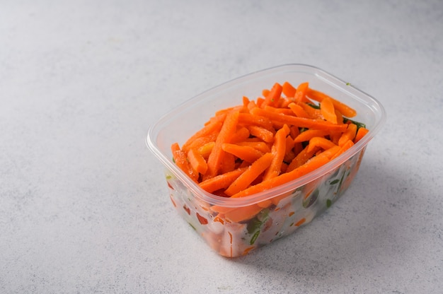 Carotte de légumes surgelés dans un bac en plastique sur une surface grise et les régimes de mise au point sélective