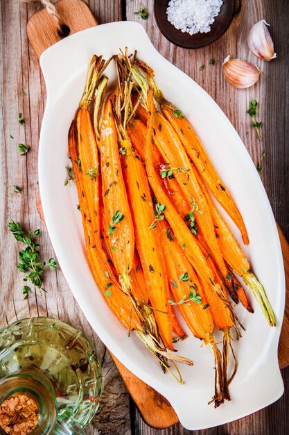 Carottes bio rôties au thym sur table en bois