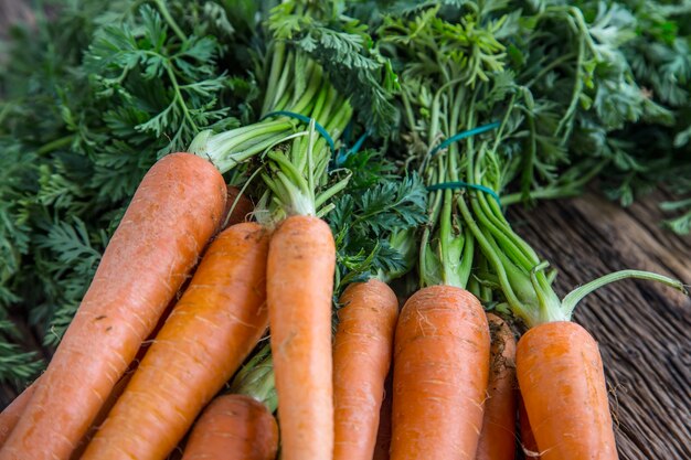 Carottes biologiques fraîches crues sur table rustique en chêne