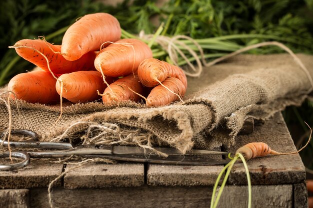 Carottes biologiques fraîches sur table rustique.