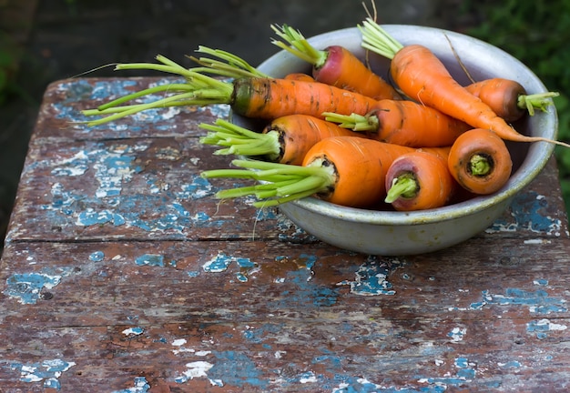 Carottes dans un bol sur une table en bois