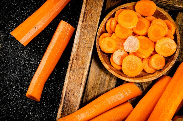 Carottes entières et tranchées sur un plateau en bois