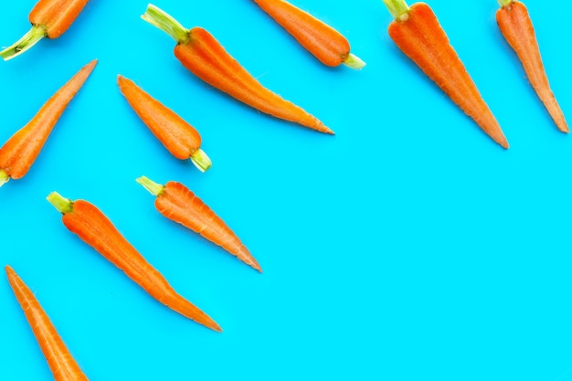 Carottes fraîches sur fond bleu.