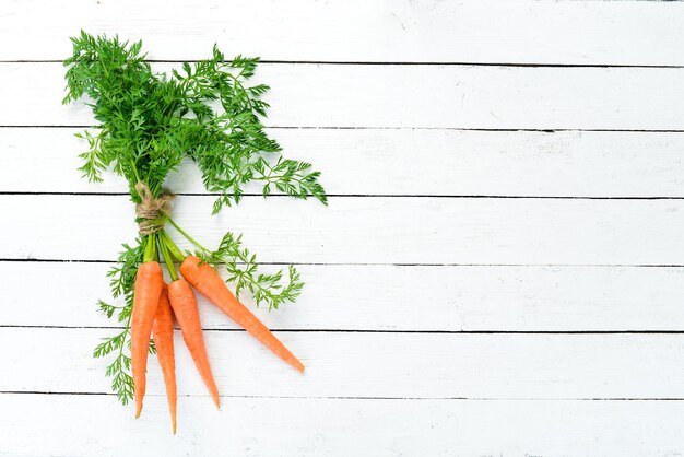 Carottes fraîches sur un fond en bois blanc Vue de dessus Espace libre pour votre texte