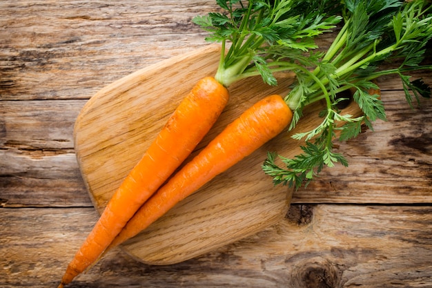 Carottes fraîches sur le fond en bois.