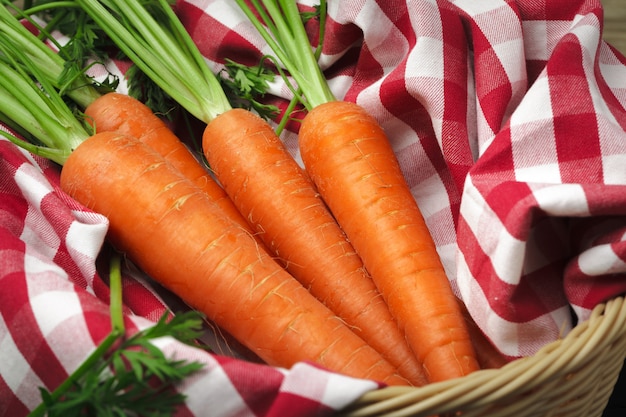 Carottes fraîches sur la nappe à carreaux bouchent