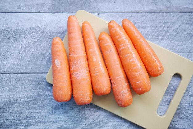 carottes fraîches sur planche à découper sur table