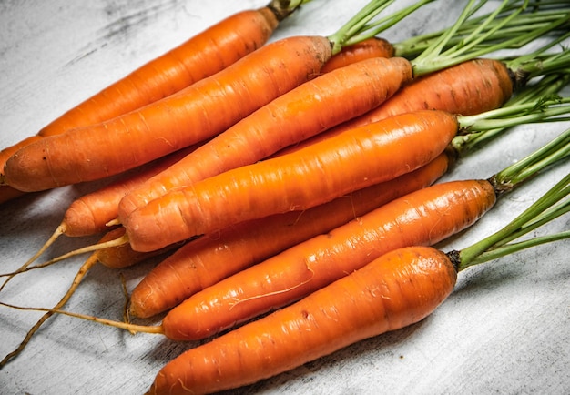 Des carottes fraîches sur une table en bois.