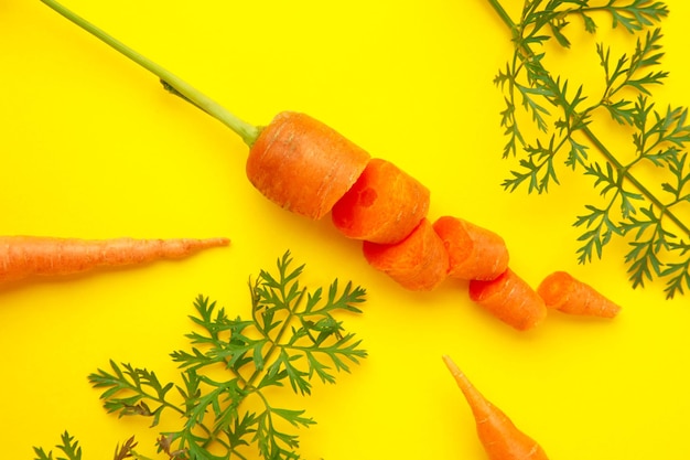 Carottes fraîches tranchées sur fond jaune Vue de haut