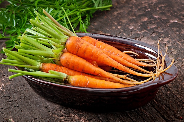 Carottes fraîches sur une vieille surface en bois