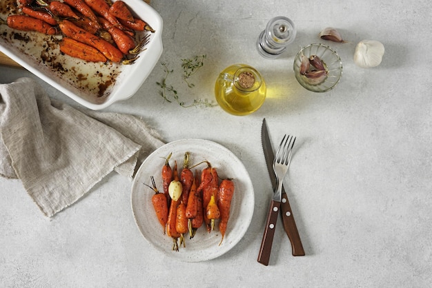 Carottes frites aux herbes servies sur l'assiette sur une table lumineuse et épices vue de dessus de la nourriture végétalienne