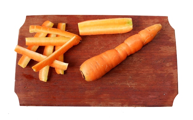 Carottes sur une planche à découper en bois isolé sur fond blanc