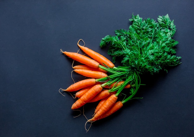 Carottes rouges fraîches sur fond sombre. Vue ci-dessus