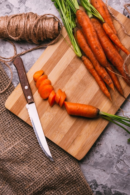 Carottes tranchées et carottes entières dans la cuisine avec un couteau