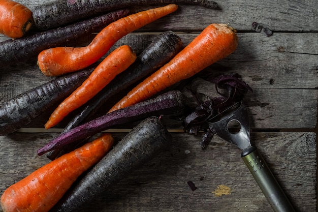 Carottes violettes et orange sur fond de bois